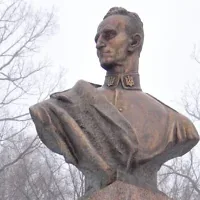 Une femme ajuste le ruban d’une couronne déposée au pied de la statue du nationaliste ukrainien Roman Shukhevych, dans la ville de Bilogorshcha, dans l’ouest de l’Ukraine, le 10 janvier 2010. Illustration (Crédit : Yuriy Dyachyshyn/AFP)