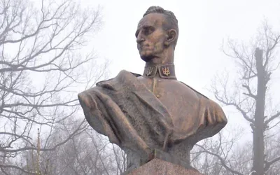 Une femme ajuste le ruban d’une couronne déposée au pied de la statue du nationaliste ukrainien Roman Shukhevych, dans la ville de Bilogorshcha, dans l’ouest de l’Ukraine, le 10 janvier 2010. Illustration (Crédit : Yuriy Dyachyshyn/AFP)