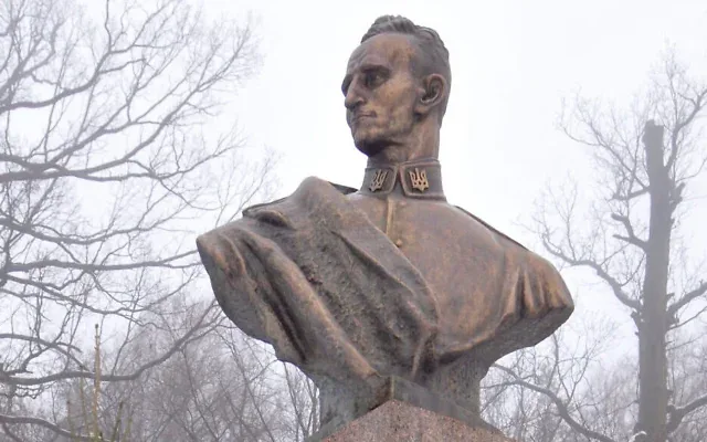 Une femme ajuste le ruban d’une couronne déposée au pied de la statue du nationaliste ukrainien Roman Shukhevych, dans la ville de Bilogorshcha, dans l’ouest de l’Ukraine, le 10 janvier 2010. Illustration (Crédit : Yuriy Dyachyshyn/AFP)
