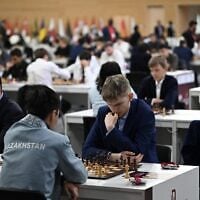 Des concurrents sont assis à leurs tables lors de la première manche des Championnats du monde de rapid et de blitz de la FIDE 2025, au Complexe des sports et des événements de l'Université du Qatar, à Doha, au Qatar, le 27 décembre 2025. (Crédit : Mahmud HAMS/AFP)