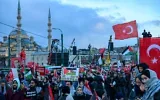 Des manifestants brandissant des drapeaux turcs et palestiniens lors d'une manifestation de solidarité avec le peuple palestinien, dans le contexte de la guerre qui oppose actuellement Israël au groupe terroriste palestinien du Hamas à Gaza, sur le pont de Galata, à Istanbul, le 1ᵉʳ janvier 2026. (Crédit : Yasin Akgul/AFP)