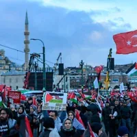 Des manifestants brandissant des drapeaux turcs et palestiniens lors d'une manifestation de solidarité avec le peuple palestinien, dans le contexte de la guerre qui oppose actuellement Israël au groupe terroriste palestinien du Hamas à Gaza, sur le pont de Galata, à Istanbul, le 1ᵉʳ janvier 2026. (Crédit : Yasin Akgul/AFP)