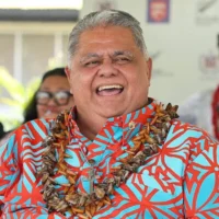 Le Premier ministre samoan, La’aulialemalietoa Leuatea Schmidt, assistant à un match de rugby opposant le Tipene College d’Auckland au Wesley College de Samoa, en compagnie de son homologue néo-zélandais Christopher Luxon, dans le village de Faleula, à Samoa, le 17 mars 2026. (Crédit : Ben Strang/AFP)