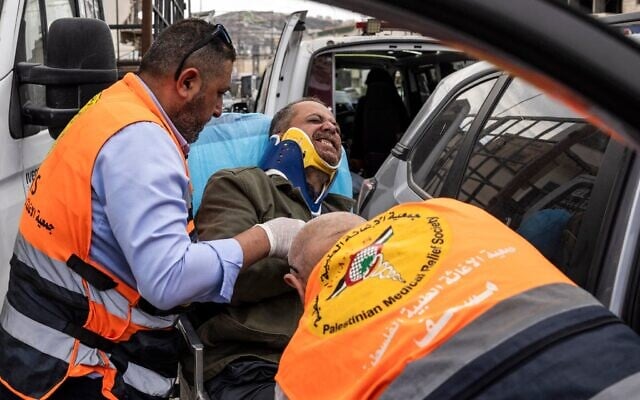 Jaafar Ashtiyeh, photographe de l'Agence France-Presse (AFP), est transporté par des secouristes palestiniens pour recevoir des soins médicaux après avoir été passé à tabac par plusieurs Israéliens à Aqraba, en Cisjordanie, le 6 octobre 2026. (Crédit : JOHN WESSELS/AFP)