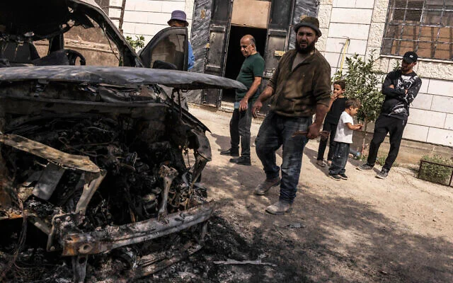 Des hommes palestiniens inspectent un véhicule incendié par des résidents d'implantations israéliens la nuit précédente, à Aqraba en Cisjordanie, le 6 octobre 2026. (JOHN WESSELS/AFP) Des hommes palestiniens inspectent un véhicule incendié par des résidents d'implantations israéliens la nuit précédente, à Aqraba en Cisjordanie, le 6 octobre 2026. (JOHN WESSELS/AFP)
