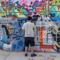 Un adolescent israélien réalisaant un graffiti dans un skatepark, à Tel Aviv, le 29 septembre 2026. (Crédit : Ilia Yefimovich/AFP)