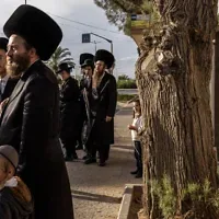 Des Juifs ultra-orthodoxes attendant à un arrêt de bus à Arad, le 1ᵉʳ octobre 2026. (Crédit : John Wessels/AFP)