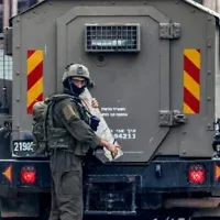 Un soldat de l'armée israélienne transporte un morceau d'un mémorial dédié aux Palestiniens accusés d'avoir tué des Israéliens ou morts lors d'affrontements, pendant une opération militaire dans le camp de réfugiés palestiniens de Jalazoun, au nord de Ramallah en Cisjordanie, le 14 octobre 2026. (Zain JAAFAR/AFP)