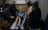 La photojournaliste américaine Heidi Levine, agressée par des résidents d’implantations israéliennes alors qu’elle photographiait des agriculteurs palestiniens récoltant leurs olives dans le village d’Abu Falah, reçoit des soins sur un brancard aux urgences de l’hôpital public de Ramallah, le 16 octobre 2026. (Crédit : Ahmad Gharabli/AFP)