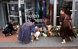 Des personnes déposent des gerbes de fleurs devant le bureau de l'élue australienne Helen Haines à Wangaratta, à environ 250 kilomètres au nord-est de Melbourne, le 20 octobre 2026. (William West/AFP)
