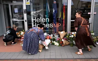 Des personnes déposent des gerbes de fleurs devant le bureau de l'élue australienne Helen Haines à Wangaratta, à environ 250 kilomètres au nord-est de Melbourne, le 20 octobre 2026. (William West/AFP)