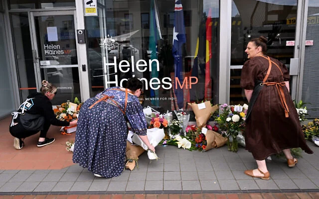 Des personnes déposent des gerbes de fleurs devant le bureau de l'élue australienne Helen Haines à Wangaratta, à environ 250 kilomètres au nord-est de Melbourne, le 20 octobre 2026. (William West/AFP)