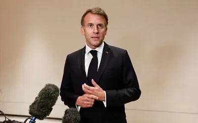 Le président français Emmanuel Macron s'adressant aux journalistes le jour du 9ᵉ sommet annuel des fonds souverains « One Planet » (OPSWF), à Lusail, le 21 octobre 2026. (Crédit : Benoît Tessier/POOL/AFP)