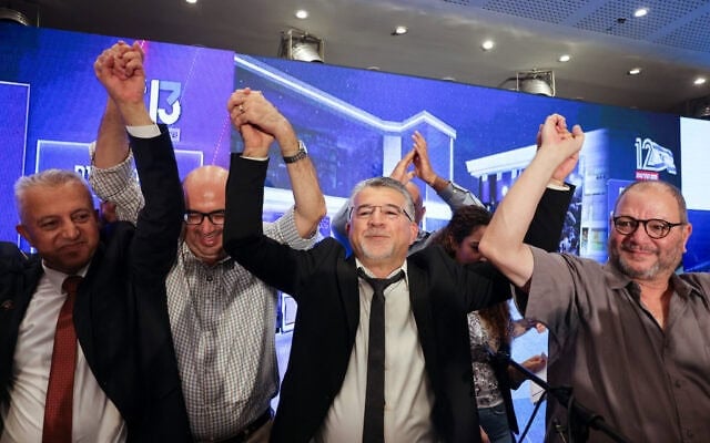 Youssef Jabareen, chef de file de la Liste arabe unie (au centre), et d’autres membres de cette alliance politique dirigée par des Arabes israéliens applaudissant à l’annonce des premiers sondages à la sortie des urnes, diffusés à la télévision au siège de campagne de l’alliance, à Nazareth, dans le nord d’Israël, le 27 octobre 2026. (Crédit : Ahmad Gharabli/AFP) Youssef Jabareen, chef de file de la Liste arabe unie (au centre), et d’autres membres de cette alliance politique dirigée par des Arabes israéliens applaudissant à l’annonce des premiers sondages à la sortie des urnes, diffusés à la télévision au siège de campagne de l’alliance, à Nazareth, dans le nord d’Israël, le 27 octobre 2026. (Crédit : Ahmad Gharabli/AFP)