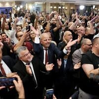 Yousef Jabareen, chef de file de l’alliance politique « Liste arabe unie » (au centre à gauche), et d’autres membres célèbrent les premiers résultats des sondages à la sortie des urnes, diffusés à la télévision au siège de campagne de l’alliance, à Nazareth, le 27 octobre 2026. (Crédit : Ahmad Gharabli/AFP)