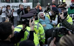 Une militante pro-palestinienne et anti-israélienne est emmenée par des policiers après avoir été arrêtée lors d’une manifestation en soutien à "Palestine Action" – que le gouvernement britannique a classé comme groupe terroriste – devant l’ambassade des États-Unis à Londres, le 31 octobre 2026. (Crédit: Carlos Jasso/AFP)