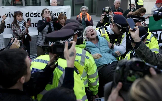 Une militante pro-palestinienne et anti-israélienne est emmenée par des policiers après avoir été arrêtée lors d’une manifestation en soutien à "Palestine Action" – que le gouvernement britannique a classé comme groupe terroriste – devant l’ambassade des États-Unis à Londres, le 31 octobre 2026. (Crédit: Carlos Jasso/AFP)