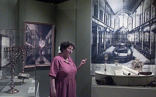 Illustration : Riki Greenspan, guide au musée McKissick de l'université de Caroline du Sud à Columbia, en Caroline du Sud, devant l'exposition retraçant 300 ans de vie juive dans le Sud de l'État, le 30 avril 2002. (Crédit : Lou Krasky/AP)