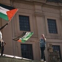 Des manifestants pro-palestiniens et anti-israéliens brandissent des drapeaux au-dessus du Brooklyn Museum lors d'une manifestation réclamant un cessez-le-feu permanent à Gaza, dans l'arrondissement de Brooklyn à New York, le 31 mai 2024. (Crédit : AP Photo/Andres Kudacki)