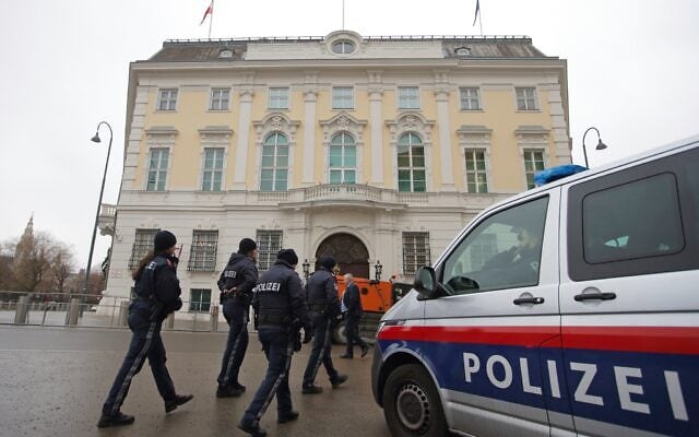 Des policiers passent devant la Chancellerie à Vienne, en Autriche, le 7 janvier 2025. (AP Photo/Heinz-Peter Bader)