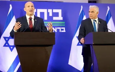 Naftali Bennett (à gauche) et Yaïr Lapid tenant une conférence de presse commune pour annoncer qu'ils se présenteront ensemble aux prochaines élections, à Herzliya, le 26 avril 2026. (Crédit : Ariel Schalit/AP Photo)