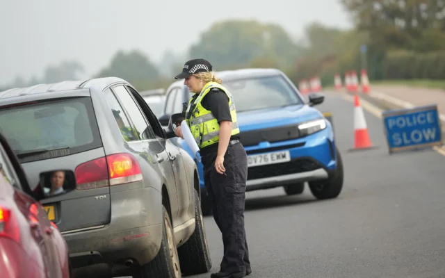 Des policiers britanniques se tiennent à un poste de contrôle près de la base aérienne de la RAF à Fairford, en Angleterre, le 29 septembre 2026. (Crédit:  AP/Alastair Grant)