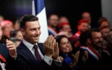 Jordan Bardella applaudissant tandis que Marine Le Pen (hors champs), présidente du Rassemblement national, prend la parole à Hénin-Beaumont, dans le nord de la France, le 13 septembre 2026. (Crédit : Jean-François Badias/AP)
