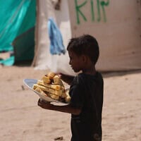 Un petit garçon yéménite déplacé transporte du pain dans le camp d'Al-Firdaws à Ras Imran, dans la banlieue ouest d'Aden, au Yémen, mardi 29 septembre 2026. (Crédit: AP/Abdulnasser Alseddik)