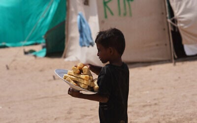 Un petit garçon yéménite déplacé transporte du pain dans le camp d'Al-Firdaws à Ras Imran, dans la banlieue ouest d'Aden, au Yémen, mardi 29 septembre 2026. (Crédit: AP/Abdulnasser Alseddik)