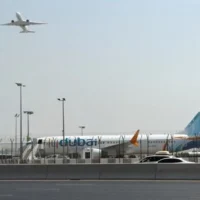 Un avion décollant tandis qu'un appareil de la compagnie flydubai est stationné sur le tarmac de l'aéroport international de Dubaï, à Dubaï, aux Émirats arabes unis, le 30 septembre 2026. (Crédit : AP Photo)