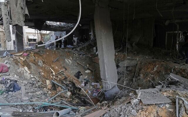 Des Palestiniens inspectent le site d'une frappe aérienne israélienne menée aux premières heures de la matinée à Gaza-City, le 3 octobre 2026. (Crédit : AP Photo/Jehad Alshrafi) Des Palestiniens inspectent le site d'une frappe aérienne israélienne menée aux premières heures de la matinée à Gaza-City, le 3 octobre 2026. (Crédit : AP Photo/Jehad Alshrafi)
