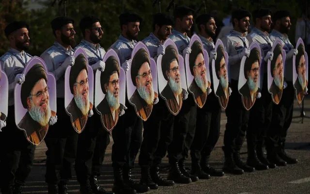Des membres des « Scouts al-Mahdi » du Hezbollah brandissent des portraits des dirigeants du Hezbollah, Hassan Nasrallah et son cousin et successeur, Hashem Safieddine, lors d'un rassemblement marquant le deuxième anniversaire de leur assassinat lors de frappes aériennes israéliennes, à Dahiyeh, dans la banlieue sud de Beyrouth, au Liban, le 4 octobre 2026. (Crédit: AP/Hassan Ammar)