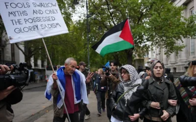 Des manifestants anti-Israël croisant un manifestant pro-Israël lors d'une marche organisée pour marquer le troisième anniversaire du pogrom perpétré par le groupe terroriste palestinien du Hamas le 7 octobre 2023, à Londres, le 7 octobre 2026. (Crédit : Kin Cheung/AP)