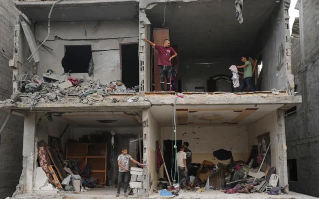 Des Palestiniens récupèrent leurs affaires dans un bâtiment détruit par une frappe aérienne israélienne à Gaza, le 9 octobre 2026. (Crédit: AP/Jehad Alshrafi) Des Palestiniens récupèrent leurs affaires dans un bâtiment détruit par une frappe aérienne israélienne à Gaza, le 9 octobre 2026. (Crédit: AP/Jehad Alshrafi)