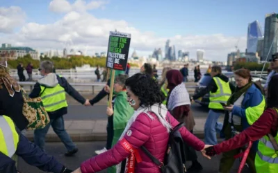 Des manifestants brandissant des pancartes et des banderoles lors d'une manifestation anti-Israël, à Londres, le 10 octobre 2026. (Crédit : Alberto Pezzali/AP)