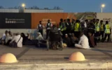 Des personnes rassemblées devant une station de métro sur la route menant à l'aéroport international King Khalid à Ryad, en Arabie saoudite, le 10 octobre 2026. (Crédit : AP Photo)
