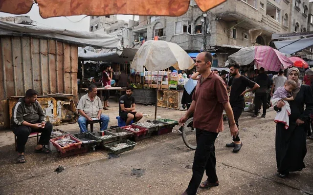 Des Palestiniens se promènent dans un marché du camp de réfugiés d’Al-Shati, à Gaza-City, le 14 octobre 2026. (Crédit : Abdel Kareem Hana/AP)