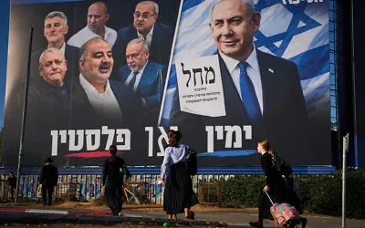 Des passants devant une affiche électorale du Likud montrant le Premier ministre Benjamin Netanyahu aux côtés de dirigeants de partis d’opposition, accompagnée du slogan en hébreu « La droite ou la Palestine », à Bnei Brak, en Israël, le 18 octobre 2026. (Crédit : Oded Balilty/AP) Des passants devant une affiche électorale du Likud montrant le Premier ministre Benjamin Netanyahu aux côtés de dirigeants de partis d’opposition, accompagnée du slogan en hébreu « La droite ou la Palestine », à Bnei Brak, en Israël, le 18 octobre 2026. (Crédit : Oded Balilty/AP)