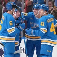 Justin Barron, des Blues de Saint-Louis, félicité par ses coéquipiers Philip Broberg (6) et Aleksanteri Kaskimaki (41) après avoir marqué un but au cours de la première période d’un match de hockey de la LNH contre les Golden Knights de Las Vegas, à Saint-Louis, le 22 octobre 2026. (Crédit : Jeff Roberson/AP Photo)
