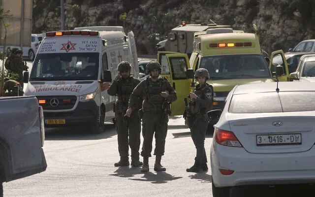 Des soldats israéliens et des membres des services d'urgence se rassemblent près d'ambulances suite à une attaque par balle perpétrée par des hommes armés palestiniens à un carrefour près d'Hébron, en Cisjordanie, le 23 octobre 2026. (Photo AP/Mahmoud Illean)