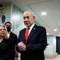 Le Premier ministre Netanyahu s’adresse aux médias aux côtés de son épouse Sara après avoir voté dans un bureau de vote à Jérusalem, le 27 octobre 2026. (Crédit : Jewel Samad/AP)