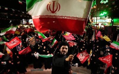 Un religieux agite un drapeau iranien alors qu'il guide les manifestants lors d'un rassemblement pro-gouvernemental à Téhéran, en Iran, le 27 octobre 2026. (AP/Vahid Salemi)
