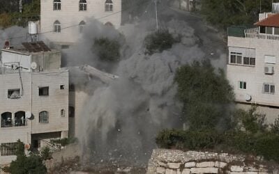 De la fumée, de la poussière et des débris s'élèvent alors que l'armée israélienne démolit deux maisons à l'aide d'explosifs, suite à une fusillade survenue le 23 octobre qui a coûté la vie à deux soldats israéliens, dans la ville d'Hébron, en Cisjordanie, le 30 octobre 2026. (AP/Mahmoud Illean)