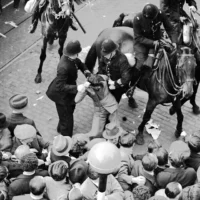 Un manifestant est arrêté et emmené par des policiers après un matraquage à cheval, dans l'East London, le 4 octobre 1936, pour mettre fin aux affrontements entre anti-fascistes et les Chemises noires de Sir Oswald Mosley. (Photo AP/Worth)