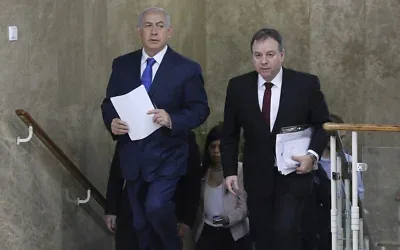 Le Premier ministre Benjamin Netanyahu, à gauche, et son chef de cabinet de l'époque, Yoav Horowitz, arrivent pour une réunion hebdomadaire du Conseil des ministres au bureau du Premier ministre à Jérusalem, le 16 décembre 2018. (Crédit: Abir Sultan/Pool via AP)