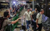 Les passagers du vol FZ1073 de flydubai, qui ont survécu à une tentative d'attentat terroriste, traversant avec leurs proches le hall des arrivées de l'aéroport Ben Gurion, près de Tel Aviv, le 30 septembre 2026, après être rentrés chez eux à bord d'un autre vol flydubai. (Crédit : Flash90)