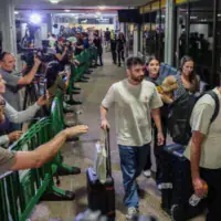 Les passagers du vol FZ1073 de flydubai, qui ont survécu à une tentative d'attentat terroriste, traversant avec leurs proches le hall des arrivées de l'aéroport Ben Gurion, près de Tel Aviv, le 30 septembre 2026, après être rentrés chez eux à bord d'un autre vol flydubai. (Crédit : Flash90)