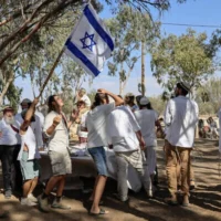Des fidèles célèbrent la fête juive de Simhat Torah sur le site du festival de musique Nova, à l'endroit où des centaines de personnes ont été assassinées par le Hamas lors du pogrom du 7-octobre, près du kibboutz Reim, dans le sud d'Israël, le 3 octobre 2026. (Tsafrir Abayov/Flash90)