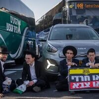 Des hommes juifs ultra-orthodoxes bloquent une route et affrontent la police lors d'une manifestation contre l'incarcération d'étudiants en yeshiva réfractaires à la conscription, à Jérusalem, le 8 octobre 2026. (Crédit : Chaim Goldberg/Flash90)