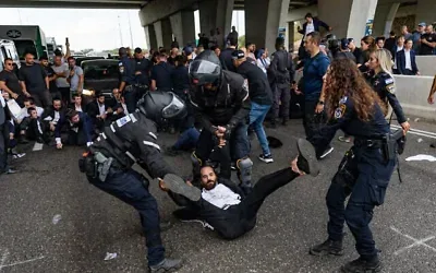 Des manifestants ultra-orthodoxes se sont affrontés avec des policiers et des civils alors qu'ils bloquaient la Route 4 lors d'une manifestation contre l'incarcération d'étudiants de yeshivot qui n'avaient pas respecté un ordre de conscription de l'armée, à l'échangeur de Yavne, le 18 octobre 2026. (Crédit : Chaïm Goldberg/Flash90) Des manifestants ultra-orthodoxes se sont affrontés avec des policiers et des civils alors qu'ils bloquaient la Route 4 lors d'une manifestation contre l'incarcération d'étudiants de yeshivot qui n'avaient pas respecté un ordre de conscription de l'armée, à l'échangeur de Yavne, le 18 octobre 2026. (Crédit : Chaïm Goldberg/Flash90)